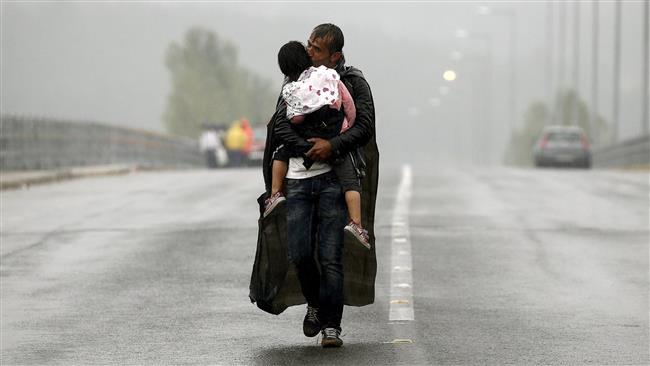 Yannis Behrakis: Refugiado sirio besando a su hijo.